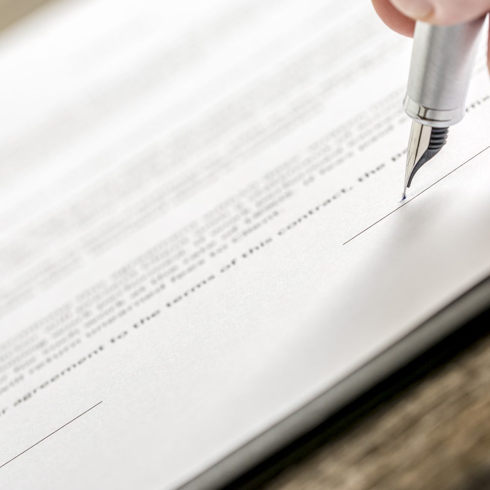 Man signing business document, subscription form or insurance pa